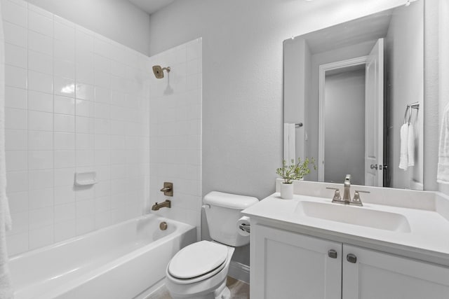 full bathroom featuring tiled shower / bath, vanity, and toilet