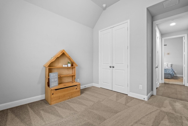 bedroom with vaulted ceiling, a closet, and carpet