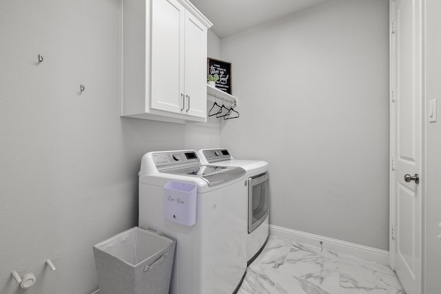 clothes washing area with cabinets and independent washer and dryer