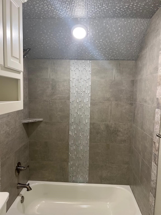 bathroom with tiled shower / bath and toilet