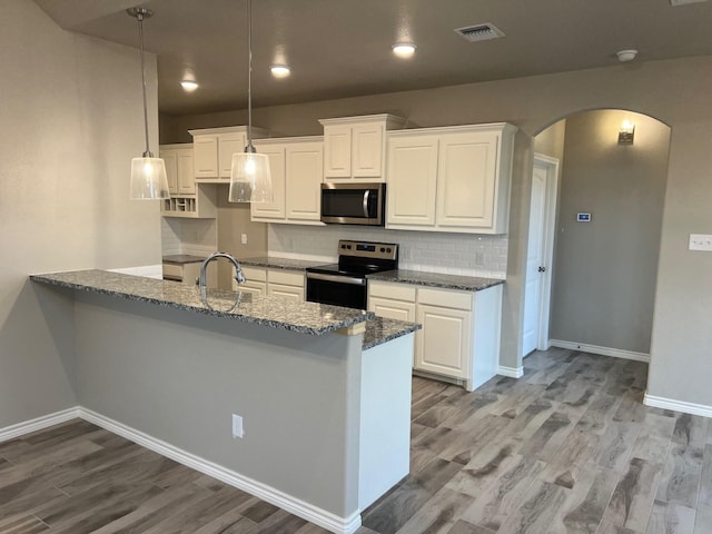 kitchen with white cabinetry, backsplash, electric range, dark stone countertops, and decorative light fixtures