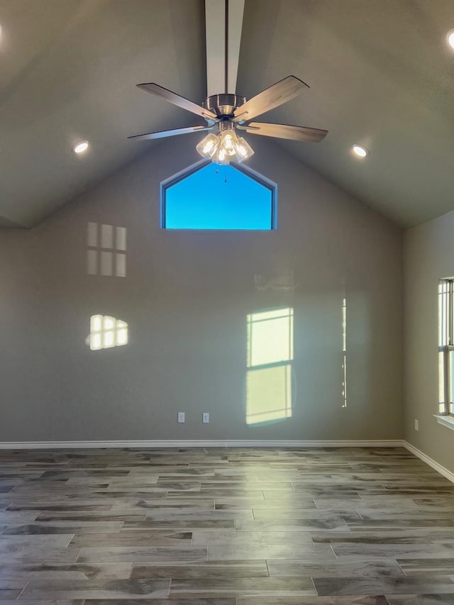 empty room featuring hardwood / wood-style flooring, ceiling fan, and high vaulted ceiling