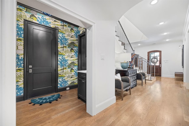 entryway featuring crown molding and light hardwood / wood-style flooring