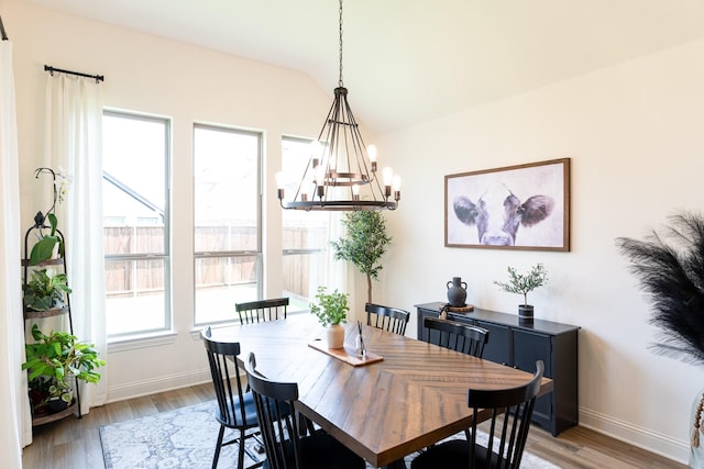 dining area with hardwood / wood-style flooring and vaulted ceiling