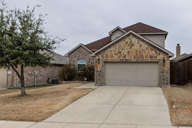 view of front property featuring a garage and cooling unit