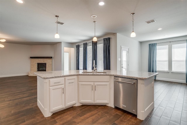 kitchen with sink, white cabinetry, hanging light fixtures, a center island with sink, and dishwasher