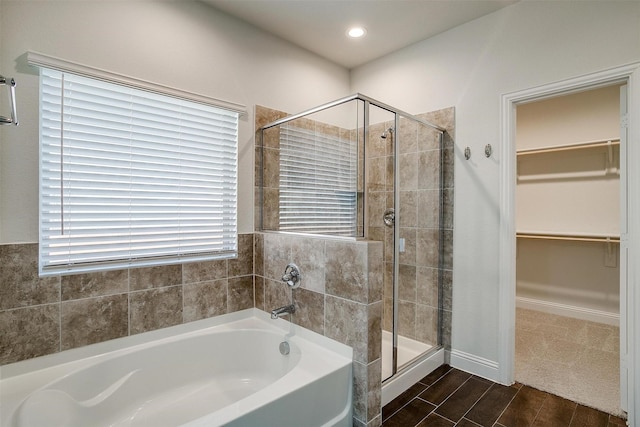 bathroom featuring plus walk in shower and wood-type flooring