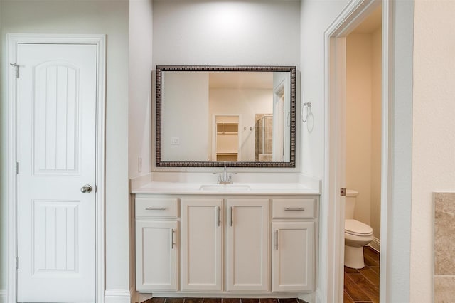 bathroom featuring vanity, hardwood / wood-style floors, and toilet