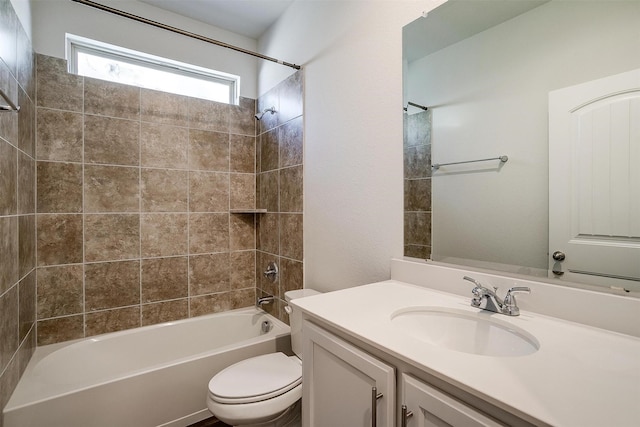 full bathroom featuring tiled shower / bath combo, vanity, and toilet