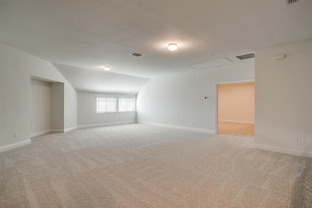 carpeted spare room with vaulted ceiling