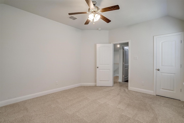 unfurnished bedroom featuring light carpet, vaulted ceiling, and ceiling fan