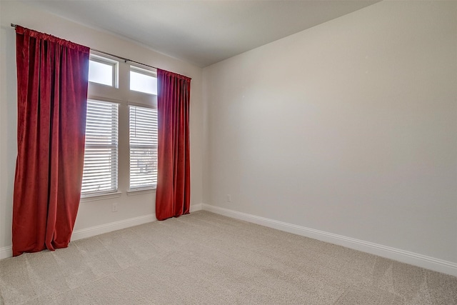 unfurnished room featuring light carpet