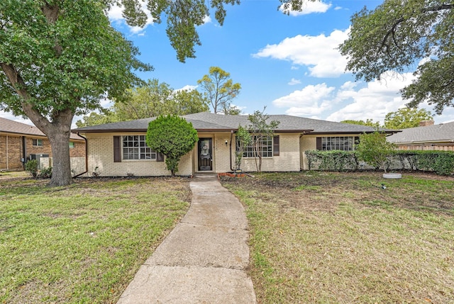 single story home featuring a front yard, brick siding, and roof with shingles