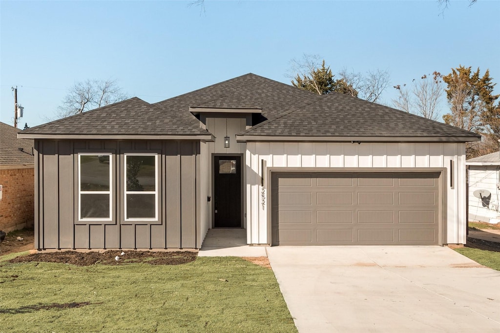 view of front of property featuring a garage and a front lawn