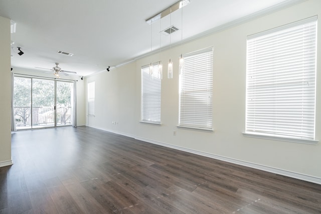 spare room featuring dark wood-type flooring, ceiling fan, and crown molding