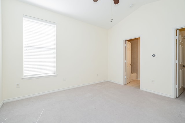 interior space with vaulted ceiling, light carpet, and ceiling fan