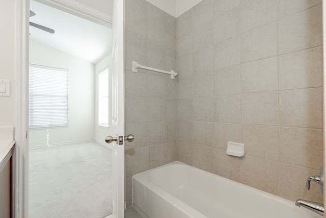 bathroom with tiled shower / bath combo and vaulted ceiling