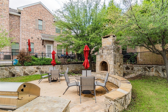 view of patio featuring area for grilling, grilling area, and an outdoor stone fireplace