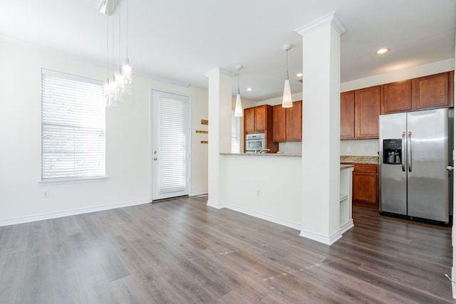 kitchen with hanging light fixtures, wood-type flooring, and appliances with stainless steel finishes