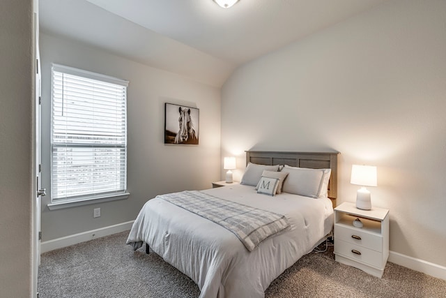 bedroom featuring light colored carpet, baseboards, and vaulted ceiling