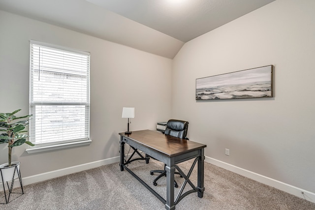 office space with baseboards, light carpet, and lofted ceiling