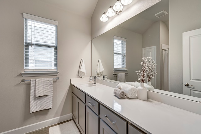 bathroom with visible vents, a shower with curtain, wood finished floors, baseboards, and vanity