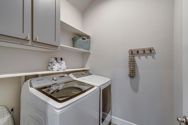 laundry room featuring washing machine and clothes dryer and cabinet space