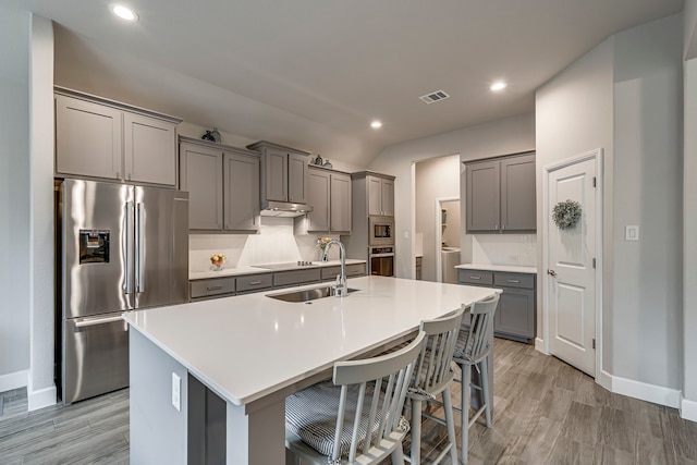 kitchen featuring visible vents, gray cabinets, appliances with stainless steel finishes, and a sink