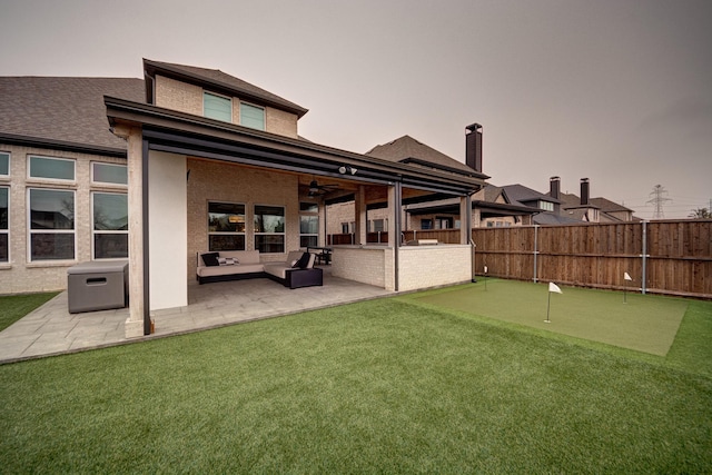 back house at dusk with an outdoor living space, a patio, and ceiling fan