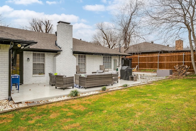 rear view of house with an outdoor living space, a yard, and a deck