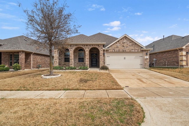 view of front of house with brick siding, concrete driveway, roof with shingles, an attached garage, and a front yard