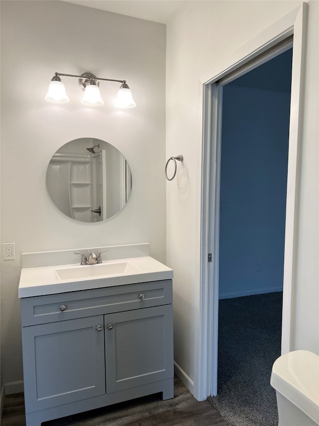 bathroom featuring vanity, hardwood / wood-style floors, and toilet