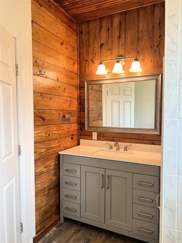 bathroom featuring hardwood / wood-style flooring, vanity, wood ceiling, and wooden walls