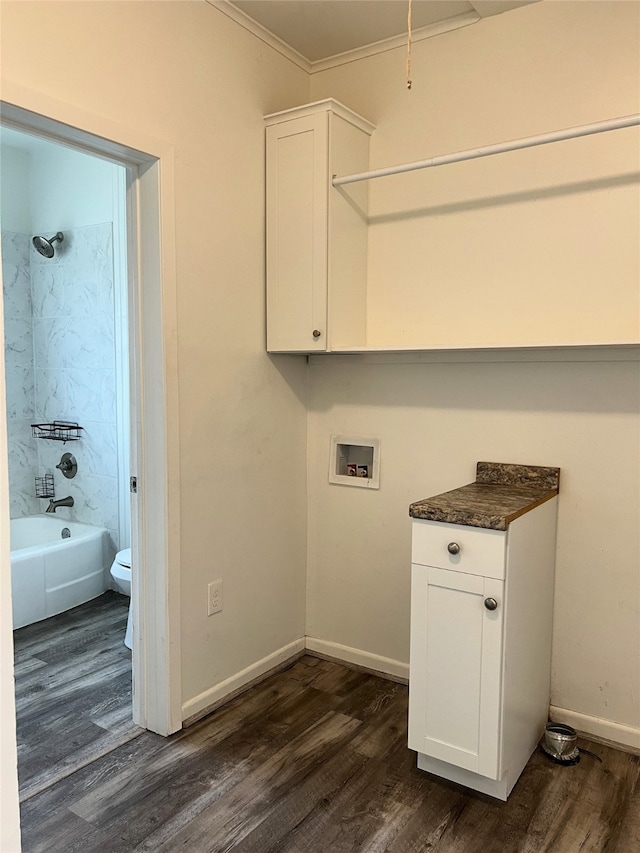 laundry room featuring ornamental molding, dark wood-type flooring, and washer hookup