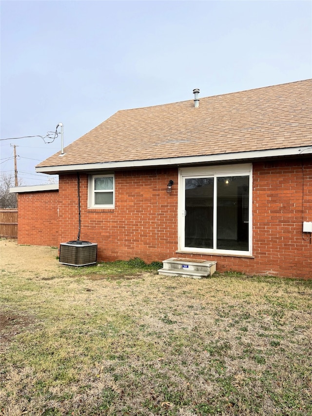 back of house featuring a yard and central AC