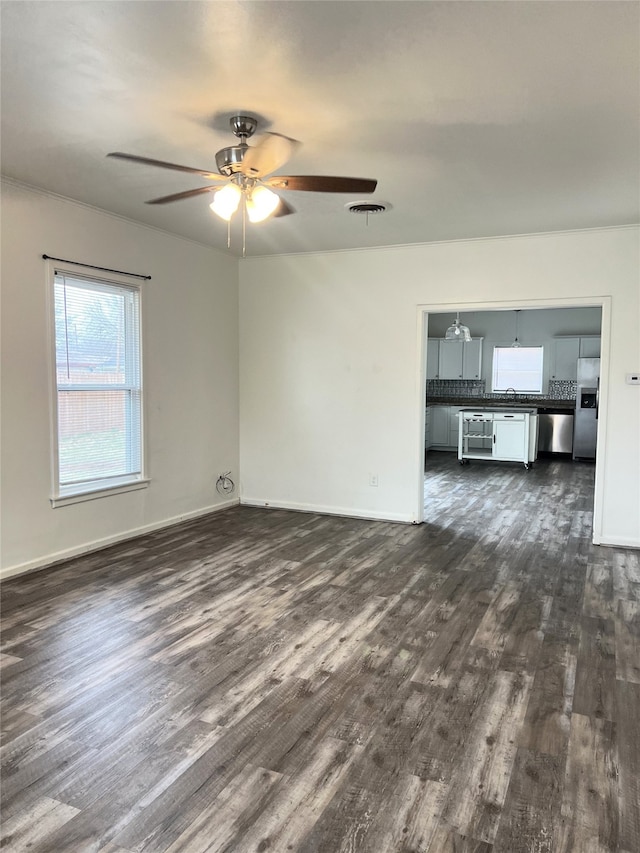 unfurnished living room featuring ceiling fan, dark hardwood / wood-style flooring, and sink