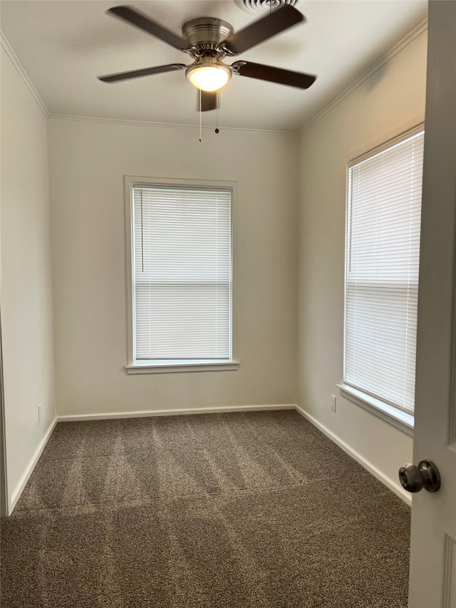 spare room with ornamental molding, ceiling fan, and dark colored carpet