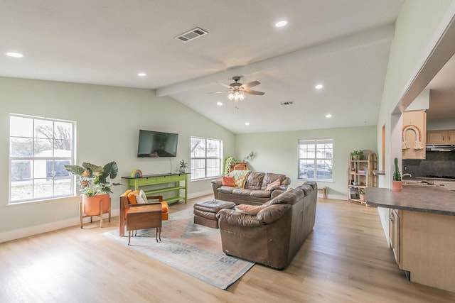 living room featuring ceiling fan, lofted ceiling with beams, and light wood-type flooring