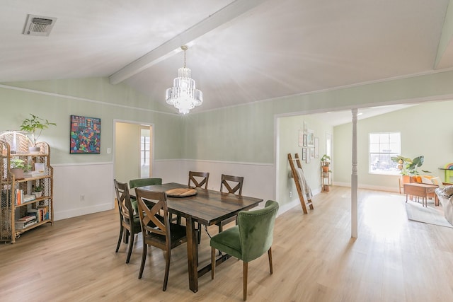 dining room featuring ornate columns, an inviting chandelier, light wood-type flooring, and vaulted ceiling with beams