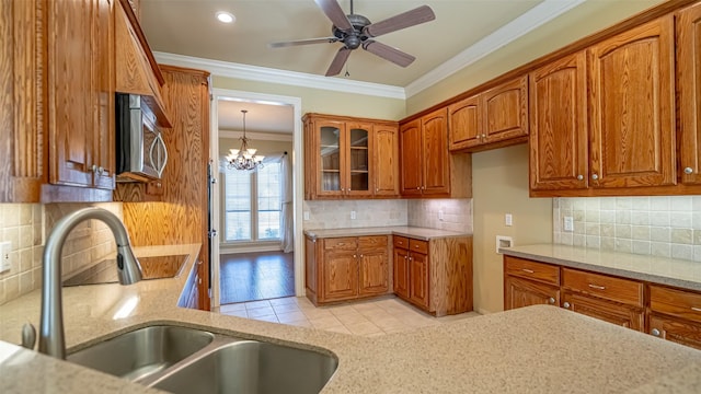 kitchen featuring ornamental molding, sink, decorative backsplash, and decorative light fixtures