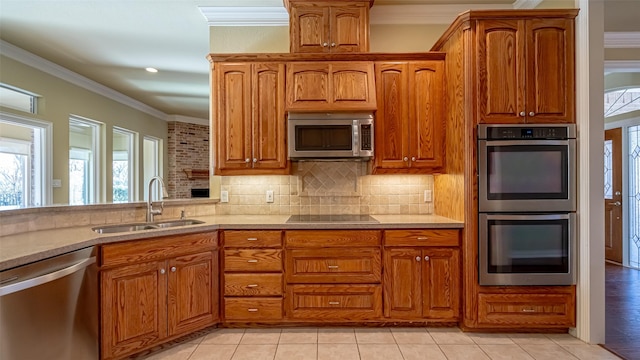 kitchen featuring light tile patterned flooring, appliances with stainless steel finishes, sink, decorative backsplash, and crown molding