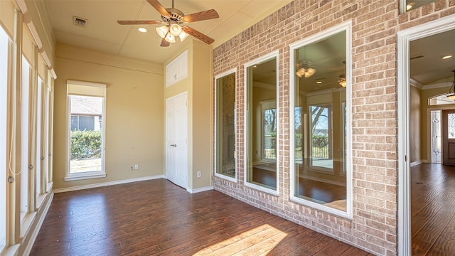 unfurnished sunroom featuring ceiling fan