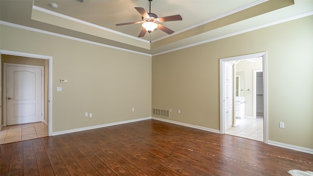 spare room with hardwood / wood-style flooring, a tray ceiling, and crown molding