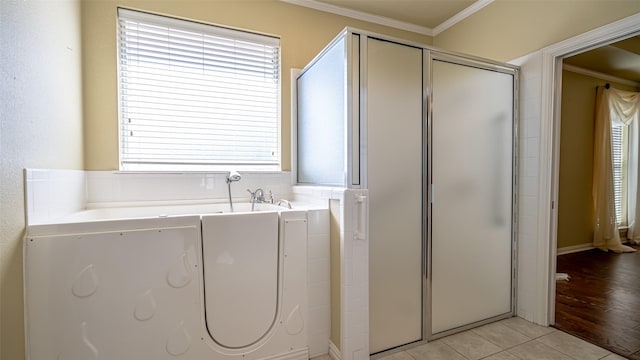 laundry area with ornamental molding and light tile patterned flooring