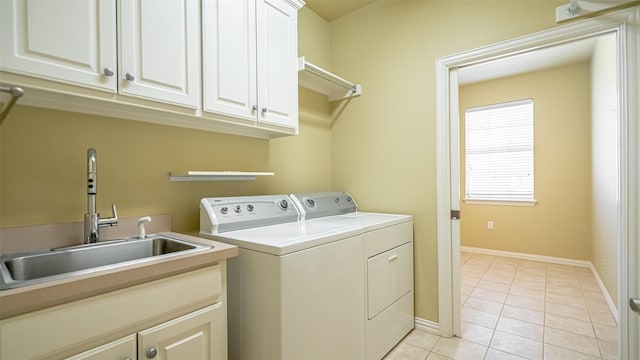 washroom with sink, washing machine and dryer, cabinets, and light tile patterned flooring