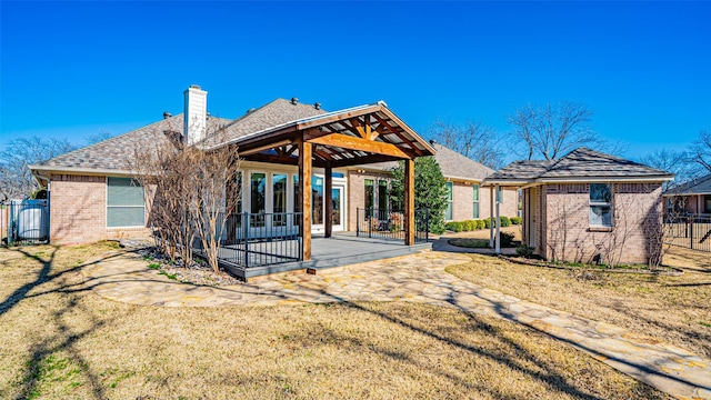 rear view of property featuring a lawn