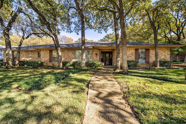 ranch-style home featuring french doors and a front lawn