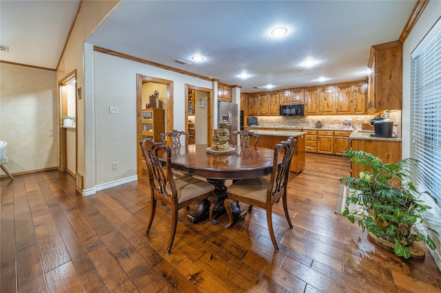 dining space featuring crown molding and hardwood / wood-style floors