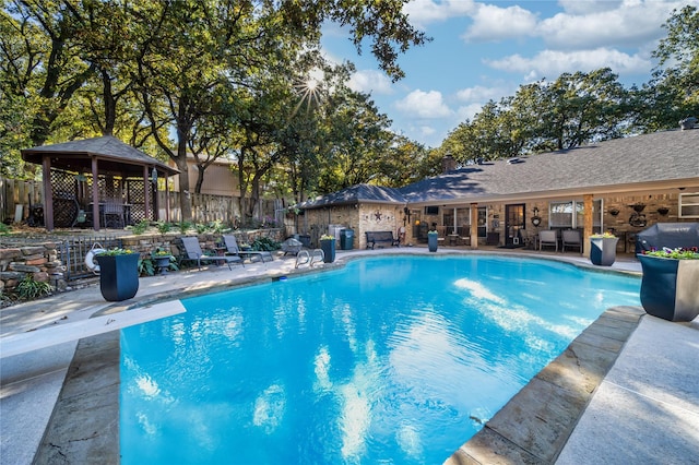 view of swimming pool with a patio, a gazebo, and a diving board