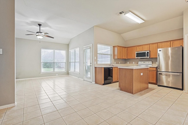 kitchen featuring a center island, vaulted ceiling, light tile patterned floors, ceiling fan, and stainless steel appliances